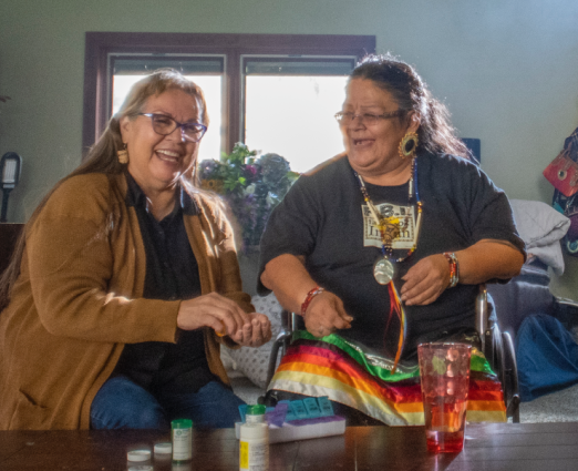 two women sitting on couch and smiling