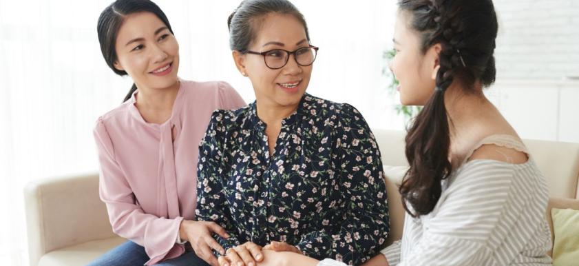 three women sitting on couch talking