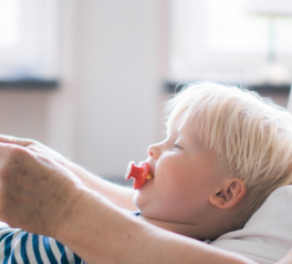 older man reading to toddler on his lap