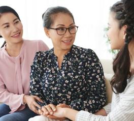 three women sitting on couch talking